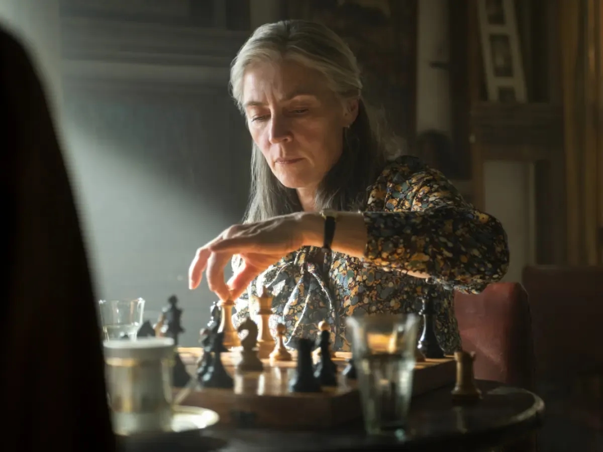 Catherine Standish playing chess in a dark room